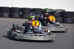 Enfants conduisant des karts numérotés 5 et 2 sur piste