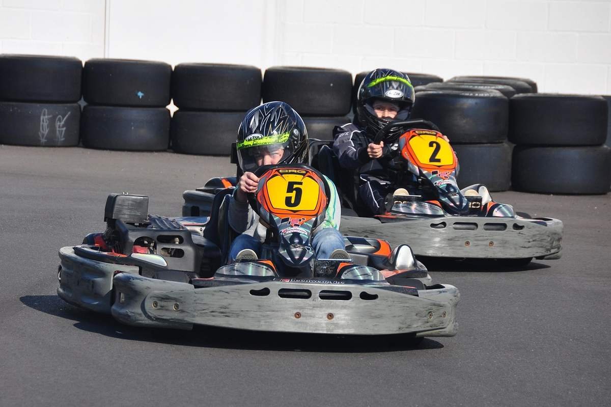 Enfants conduisant des karts numérotés 5 et 2 sur piste Enfants conduisant des karts numérotés 5 et 2 sur piste