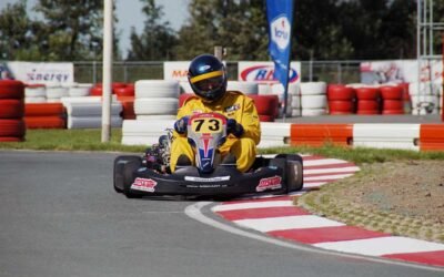 Un pilote en combinaison jaune pilote un kart sur virage