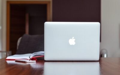Ordinateur portable Apple sur table en bois avec cahier ouvert