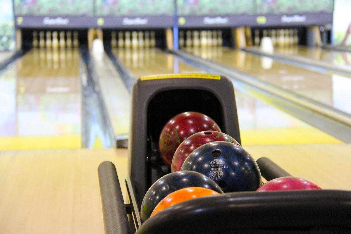 Balle de bowling dans le porte-balles, pistes et quilles visibles